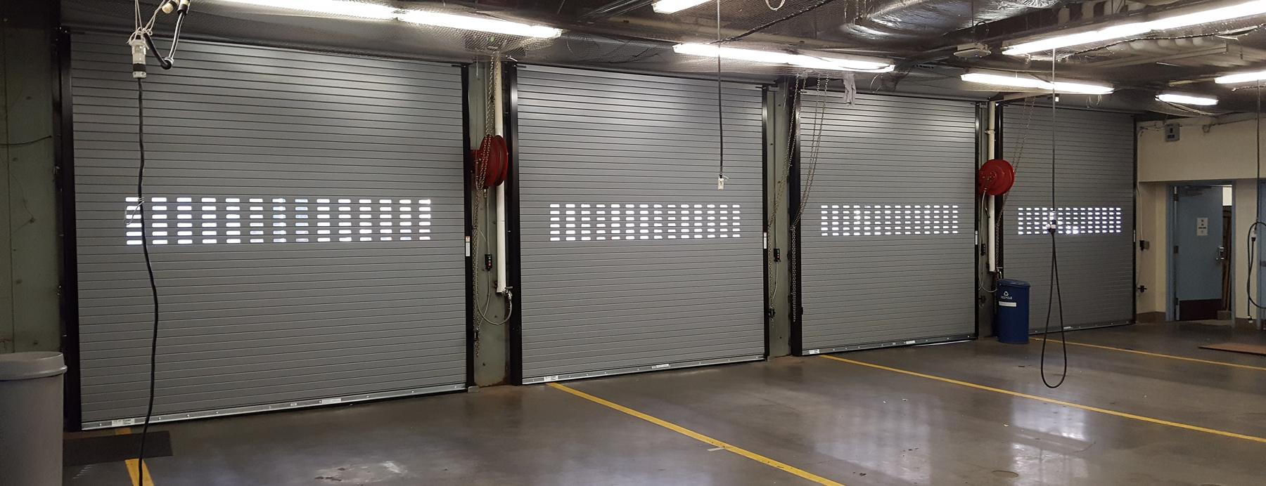 Four rolling steel doors seen from inside the service bays