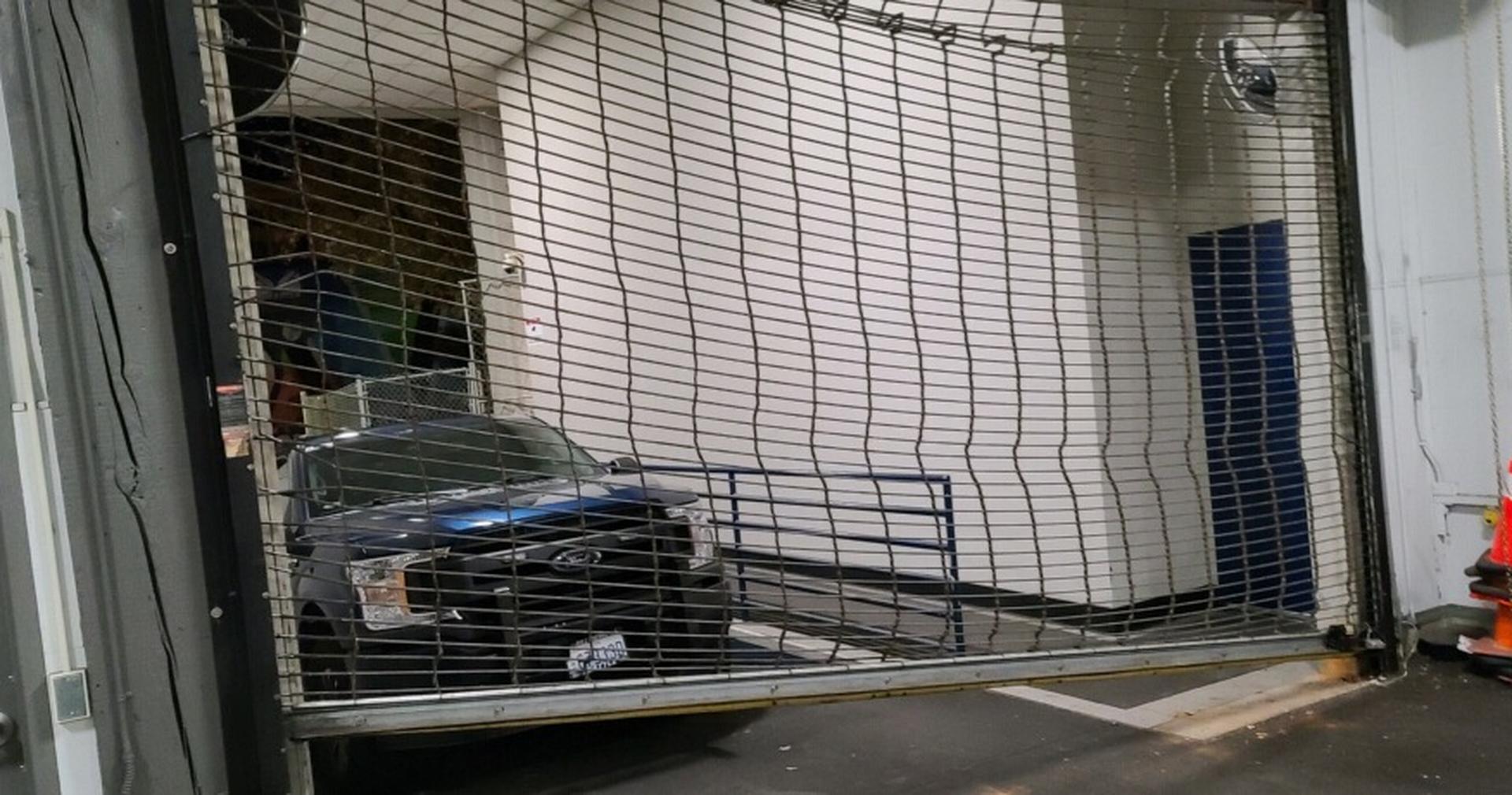 Rolling security grille pushed in by a vehicle
